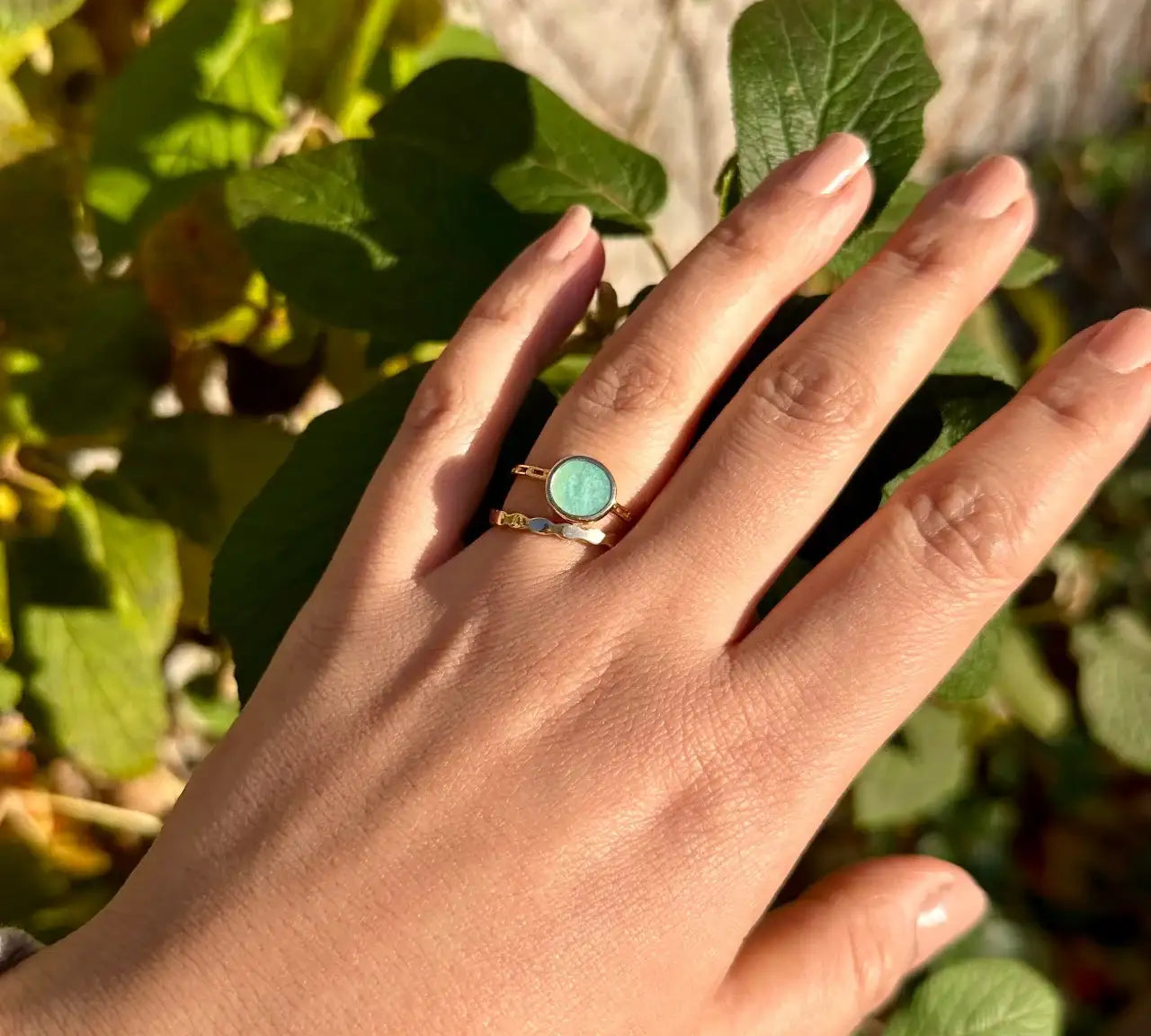 Bague dorée avec pierre amazonite sur main féminine, bijou chic en plein air