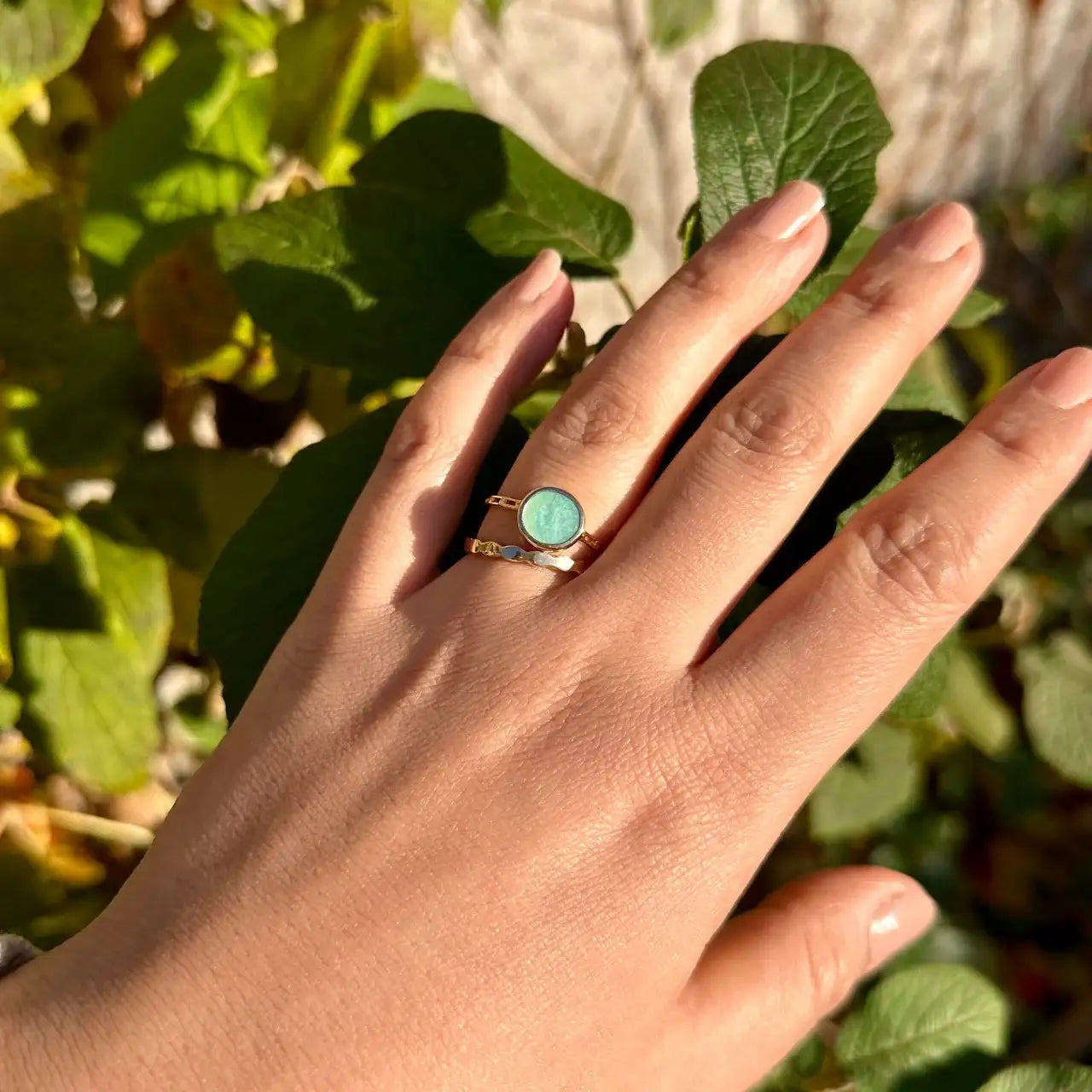 Bague dorée avec pierre amazonite sur main féminine, bijou chic en plein air