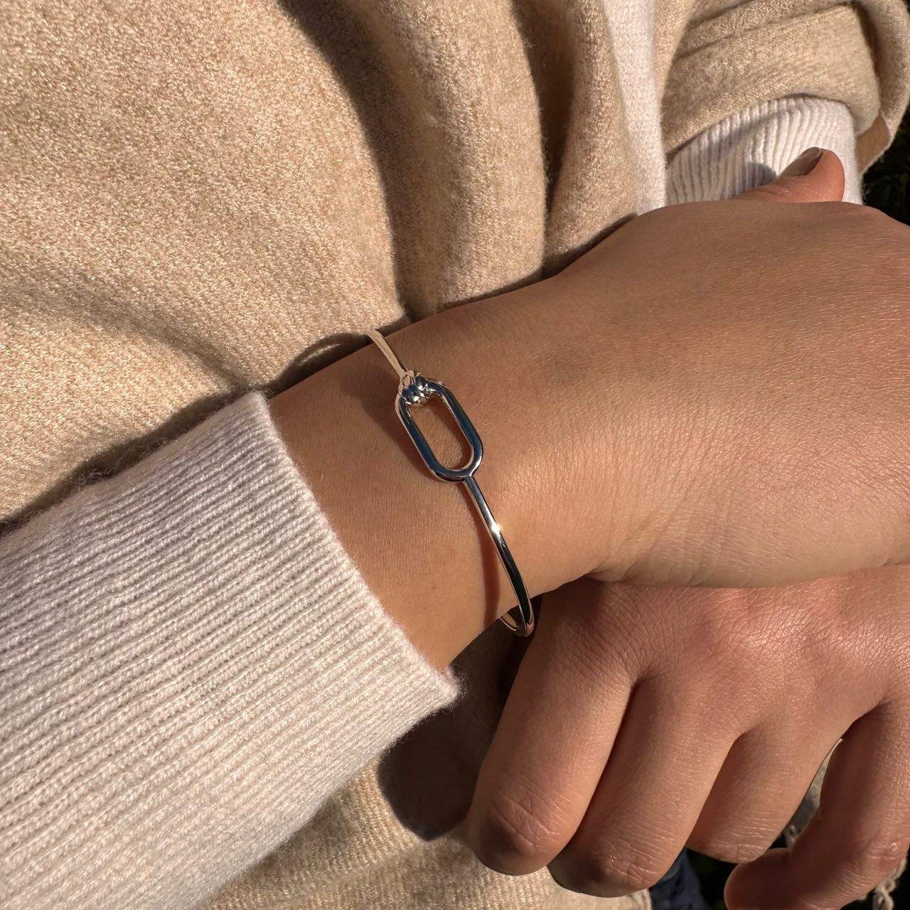 Bracelet jonc argenté élégant porté au poignet, bijou chic et minimaliste pour femme