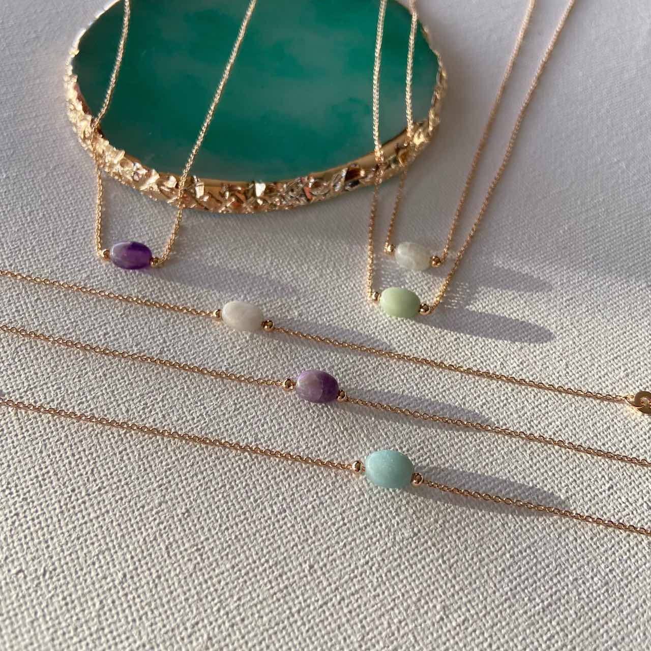 Bracelets fins dorés avec pierres colorées, bijoux chics sur fond clair