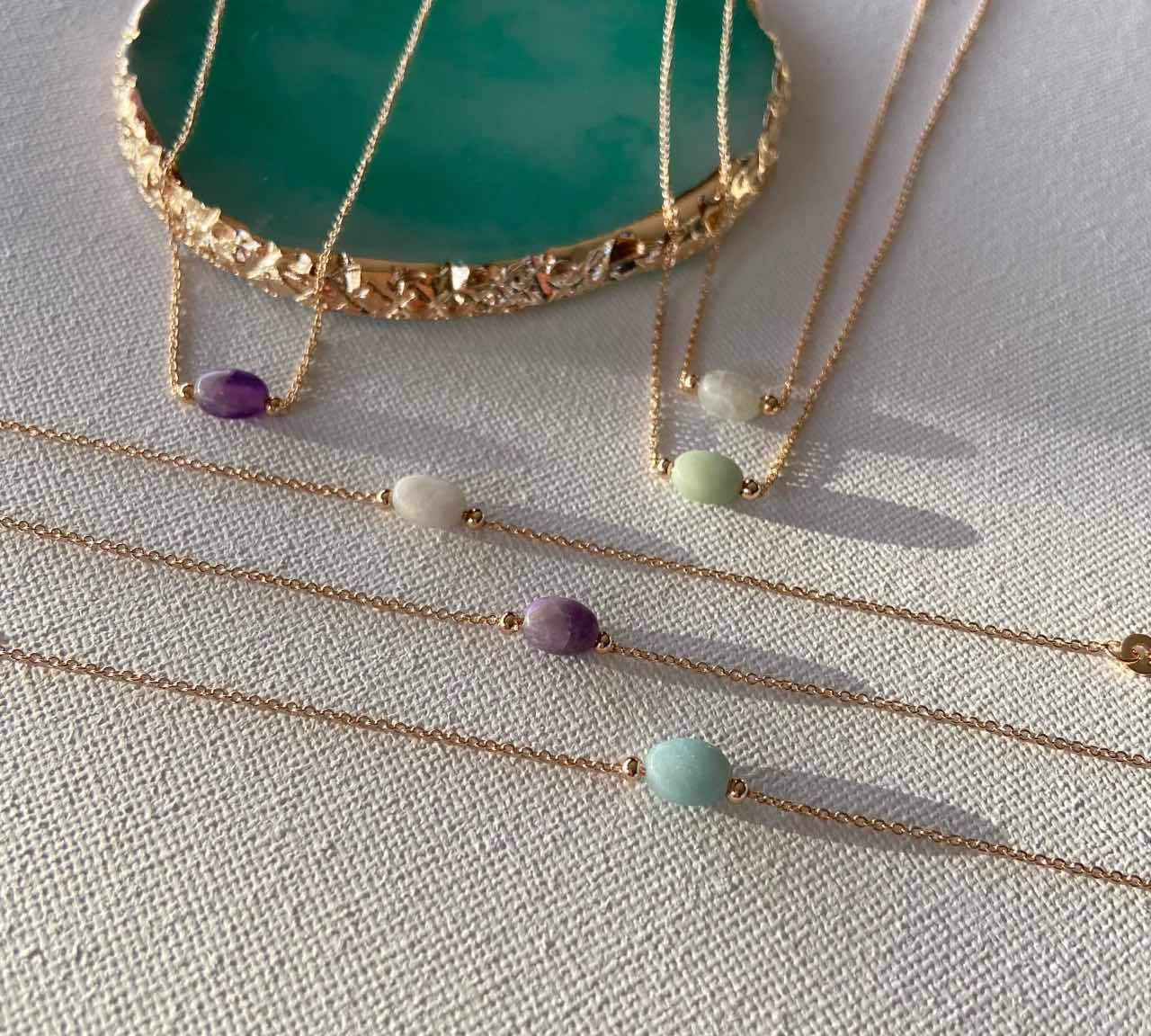 Bracelets fins dorés avec pierres colorées, bijoux chics sur fond clair