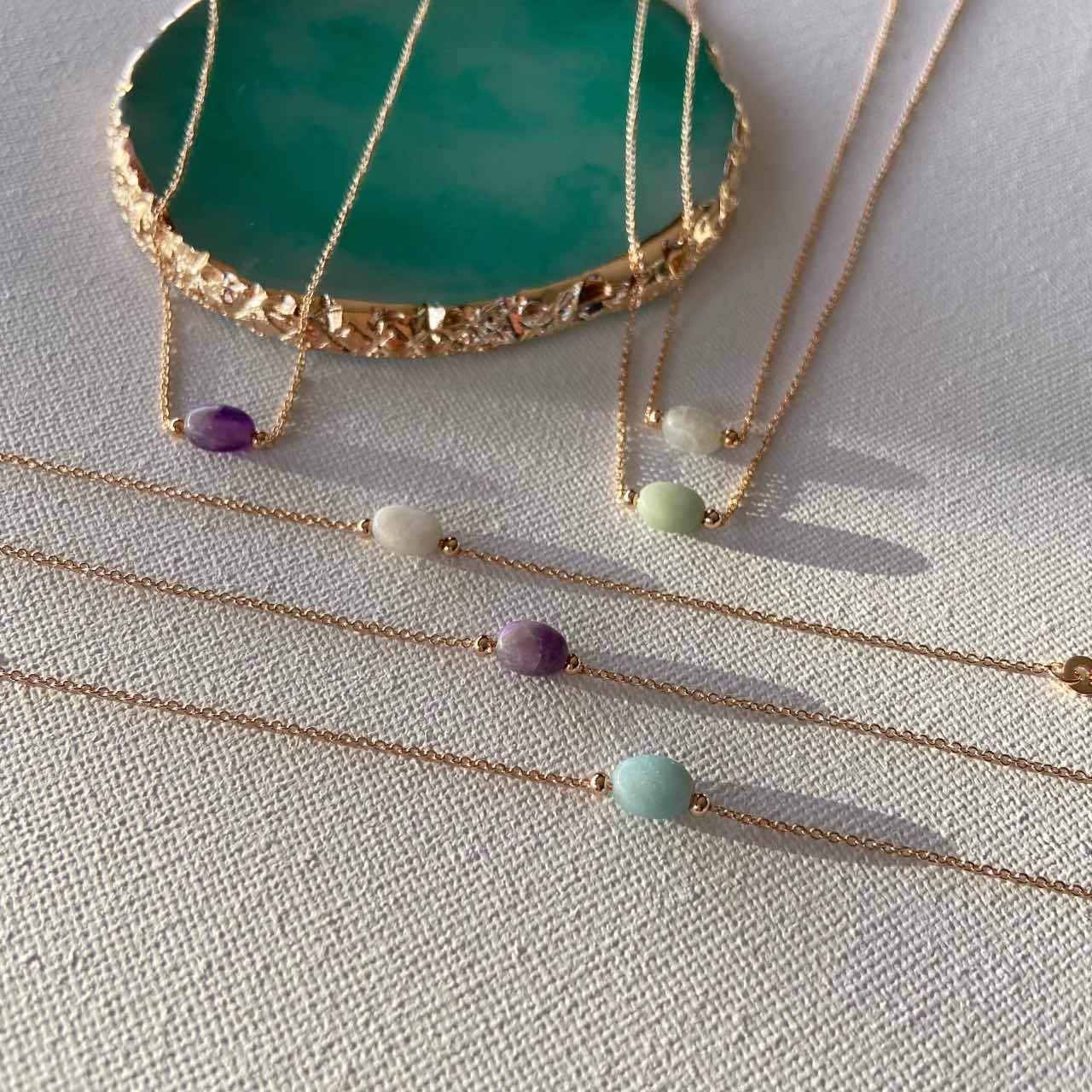 Bracelets fins dorés avec pierres colorées, bijoux chics sur fond clair