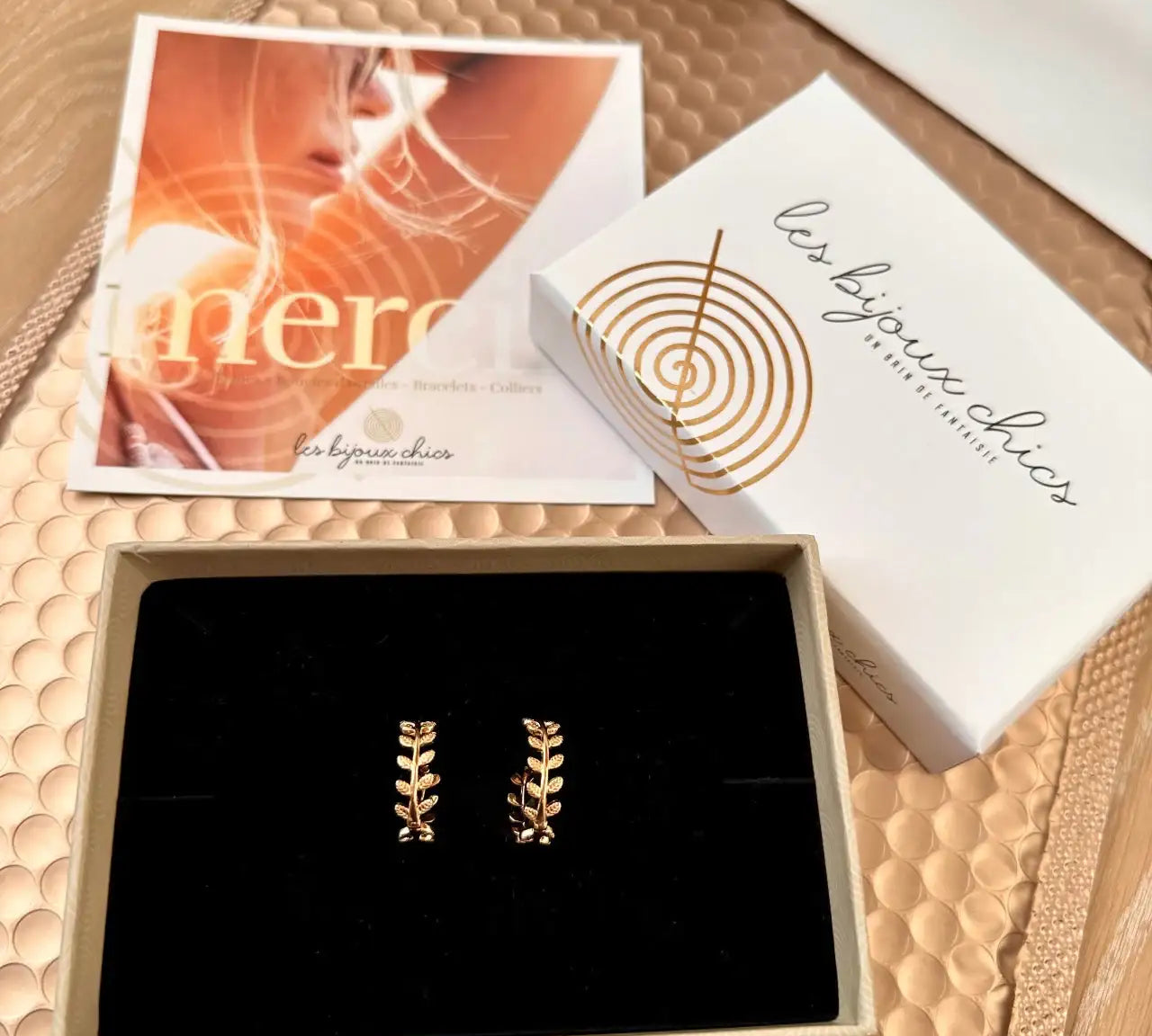 Boucles d’oreilles dorées en forme de feuilles dans un écrin cadeau élégant