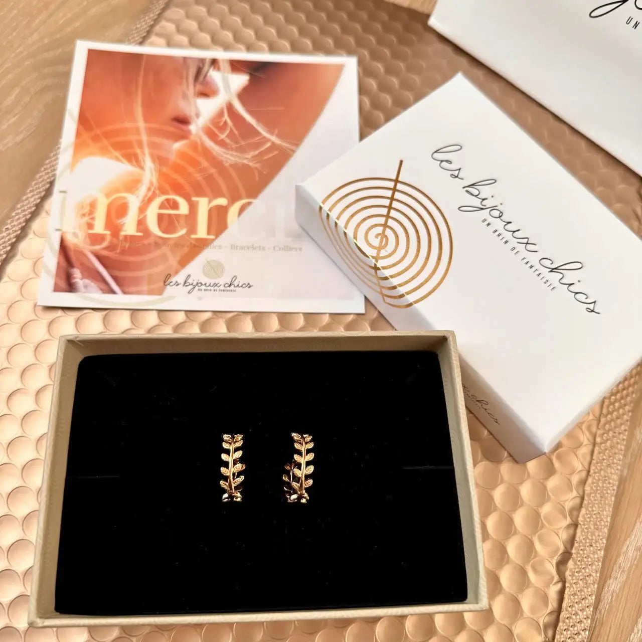 Boucles d’oreilles dorées en forme de feuilles dans un écrin cadeau élégant
