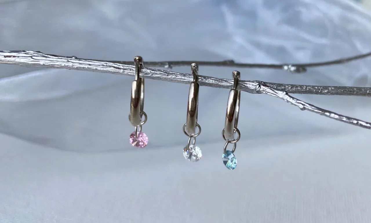 Petites créoles en argent avec pendentif zircon rose, blanc et bleu, sur fond clair