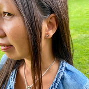 jeune femme portant boucles d'oreilles argent motif infini