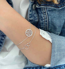 Bracelets argent portés par une jeune fille en jean