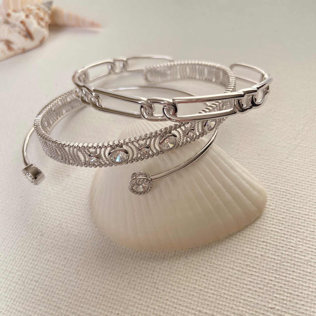 3 bracelet jonc en argent rhodié sur un coquillage