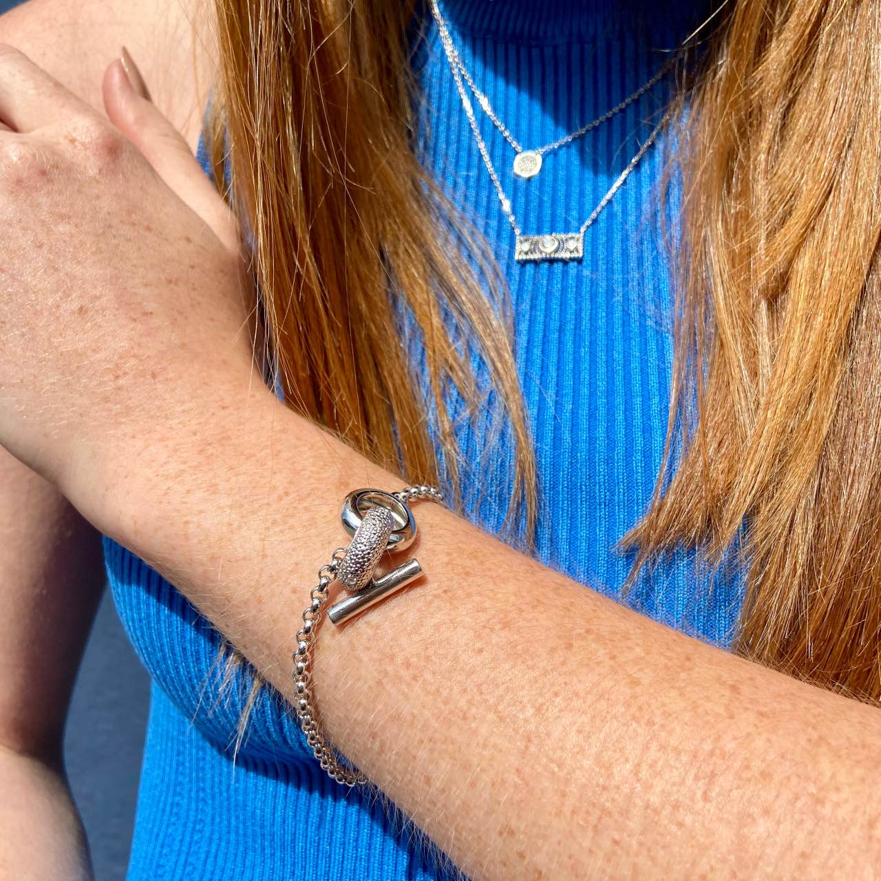 bracelet argent fermoir bascule porté par une jeune femme