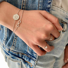 Bracelets en argent portés sur une jeune fille en jean