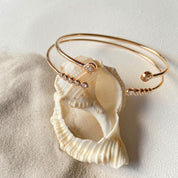 composition de deux bracelets jonc plaqué or sur un coquillage