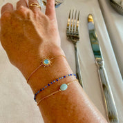 femme portant 2 bracelets plaqué or agate bleu et perles