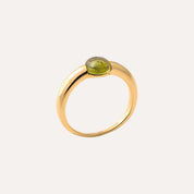 Bague en or avec péridot vert, bijou élégant sur fond clair, style chic