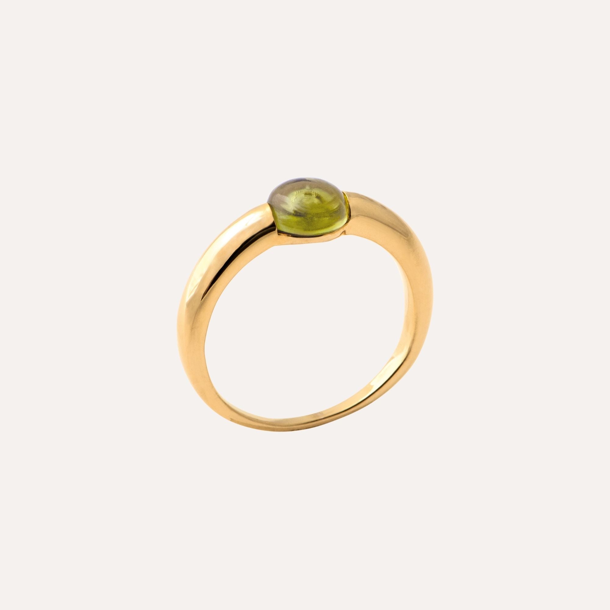 Bague en or avec péridot vert, bijou élégant sur fond clair, style chic