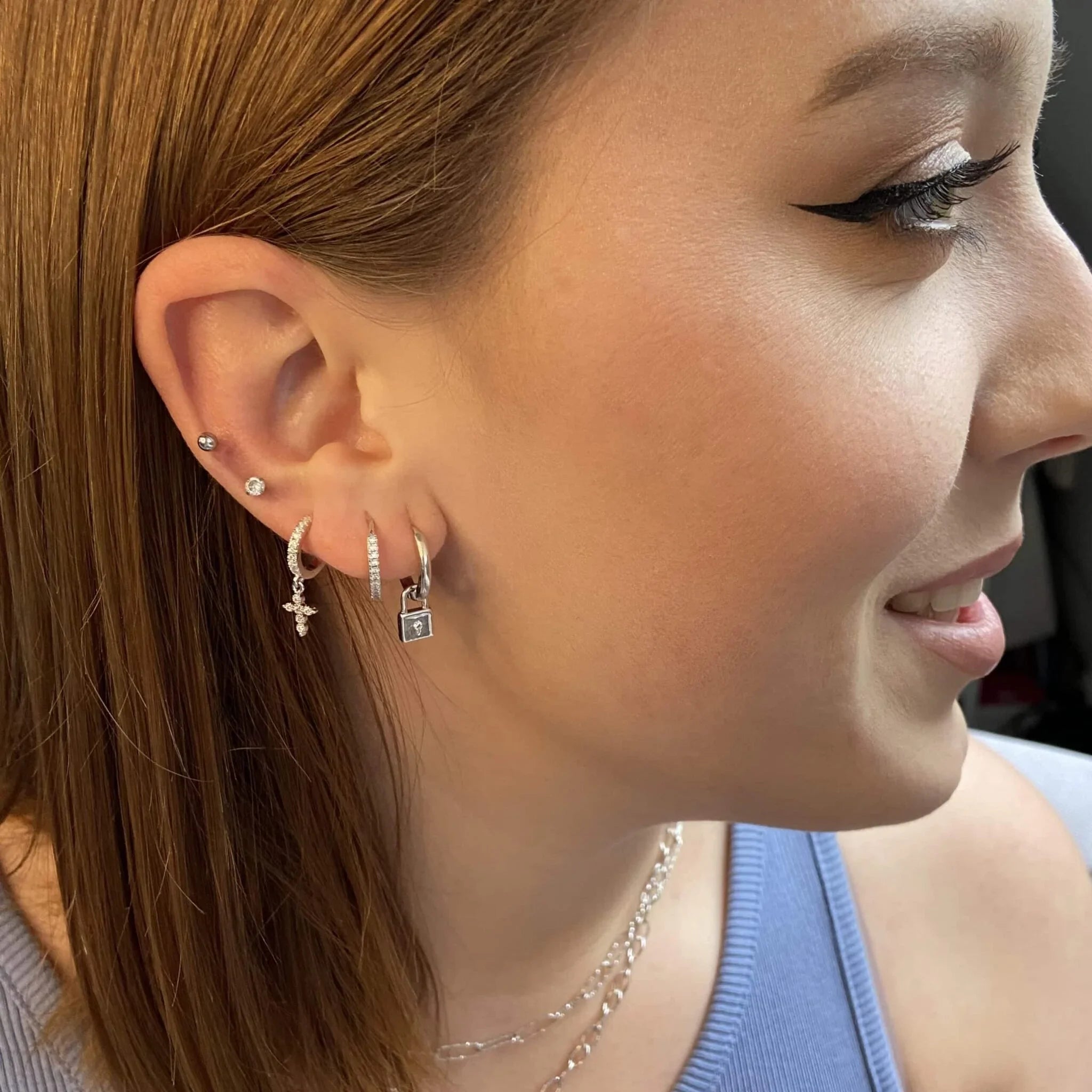 Boucles créoles avec pendentif cadenas, portées sur l’oreille
