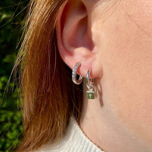 Petites créoles en argent 925 pavées de zirconium, portées sur l’oreille.