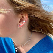 Jeune femme portant plusieurs boucles d'oreilles en argent