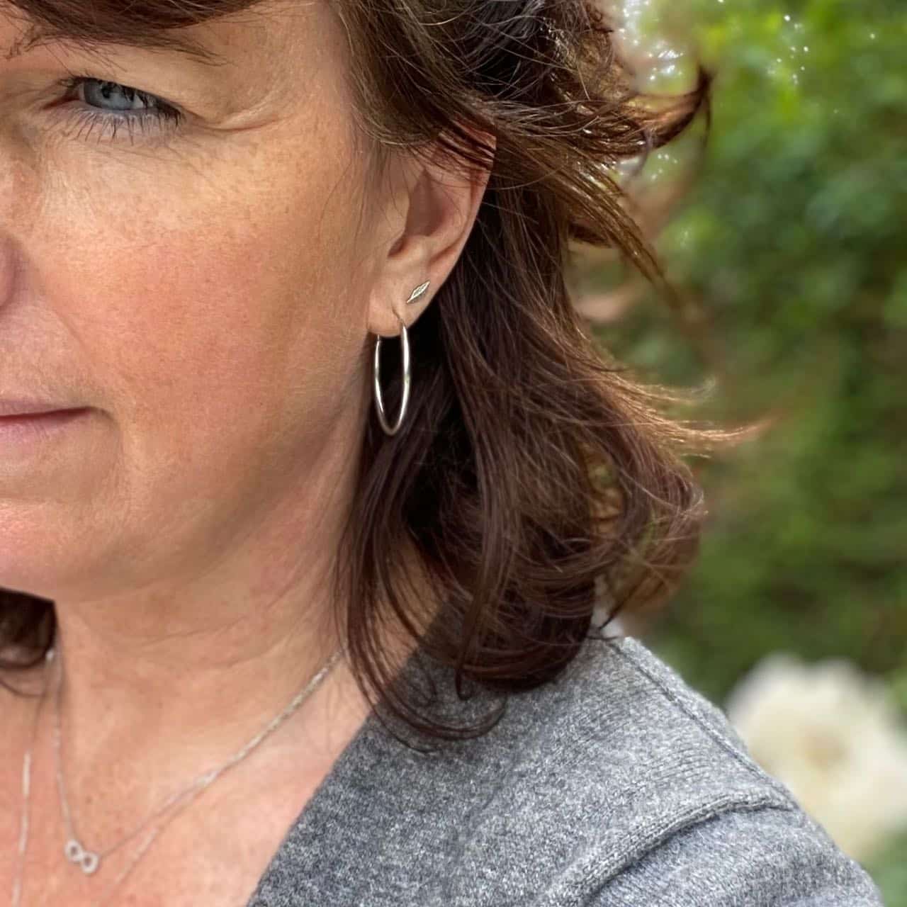 Créoles fines en argent 30 mm portées par une femme brune