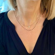 femme portant 2 colliers plaqué or perles noir et cadenas