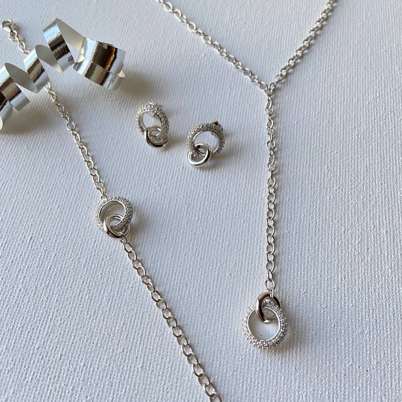 composition avec collier cravate argent, bracelet et boucles d'oreilles assorties