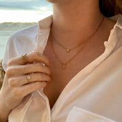 Jeune femme portant un collier plaqué or à la plage