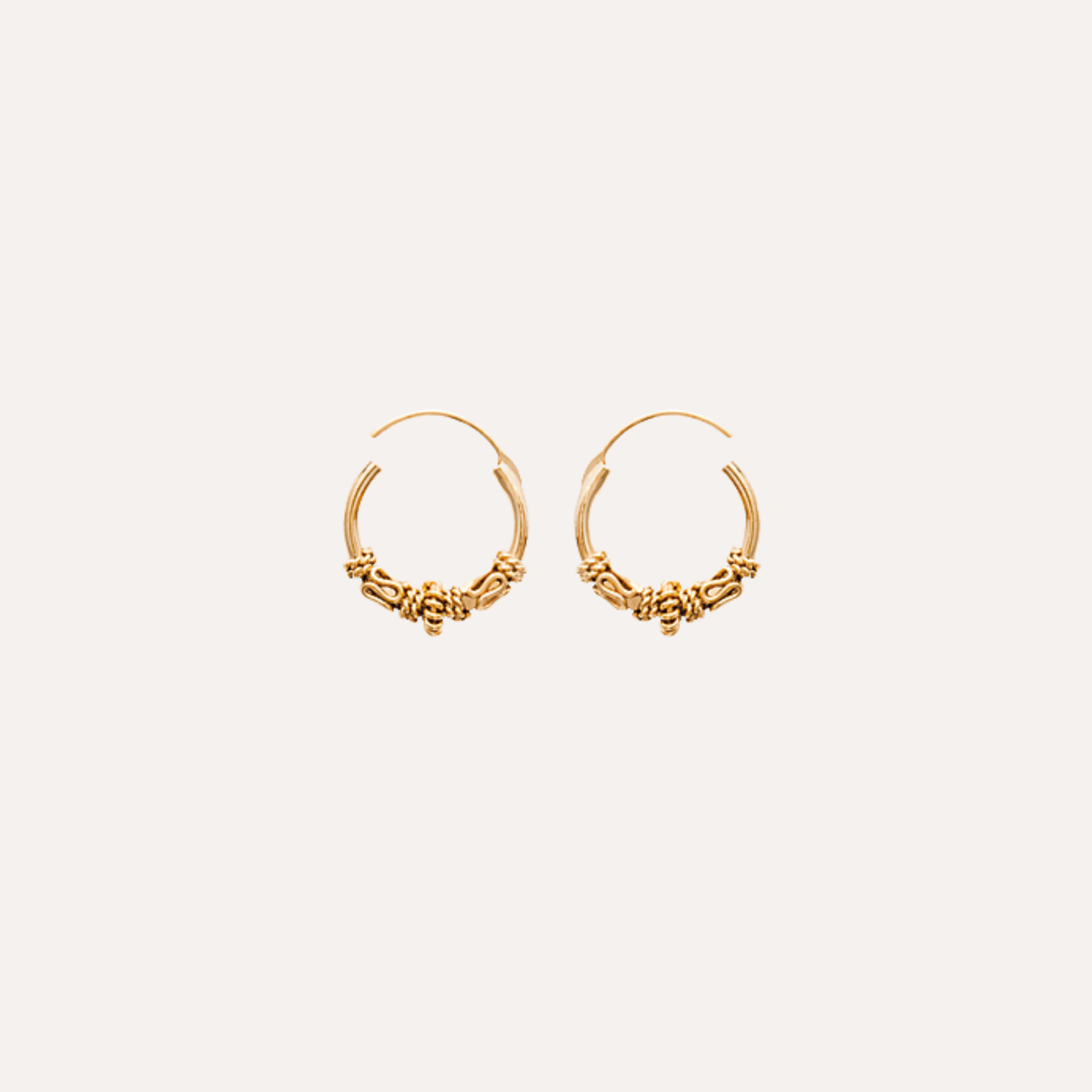 Boucles d’oreilles créoles dorées, détail torsadé, bijoux chics femme, fond blanc.