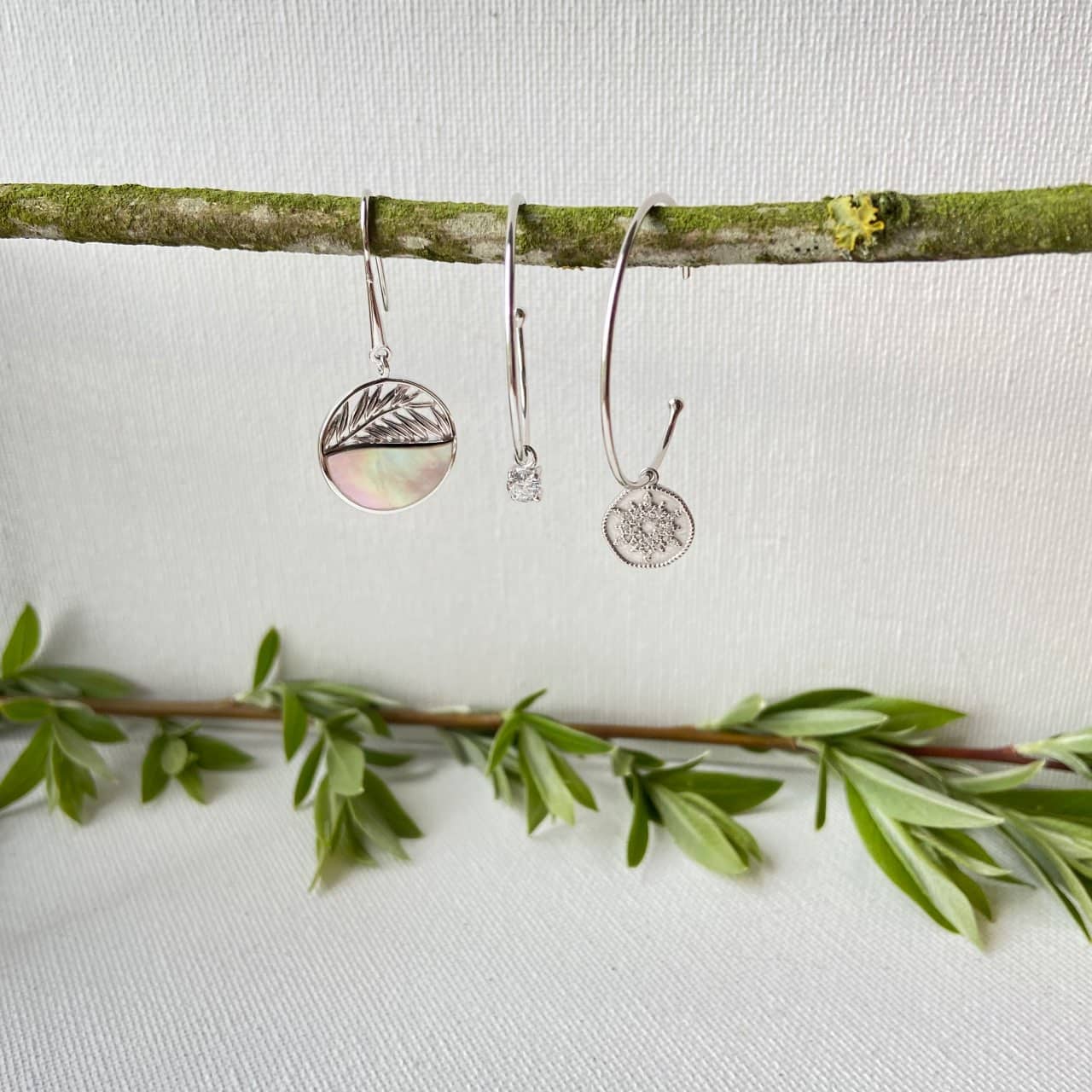 Créoles en argent sur fond végétal