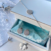 Bijoux en argent posés sur une boîte en bois blanc