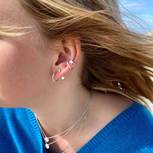 Bijoux d'oreille en argent porté par une jeune femme blonde