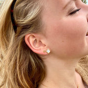 jeun femme portant des boucles d'oreilles en nacre