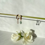 gros plan sur des petites créoles plaqué or agrémentées de perles rose et verte