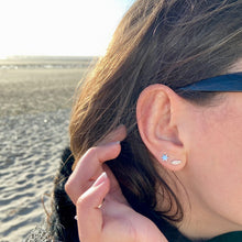 Boucles d'oreilles argent étoile plume portées par une jeune fille brune