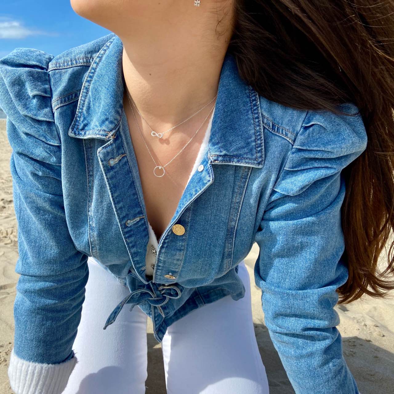 colliers cercle et infini en argent portés par une jeune fille brune