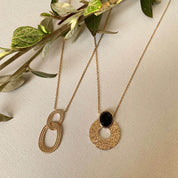 deux colliers plaqué or anneaux striés et agate noire