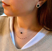 collier plaqué or perles et agate noire porté par une jeune femme