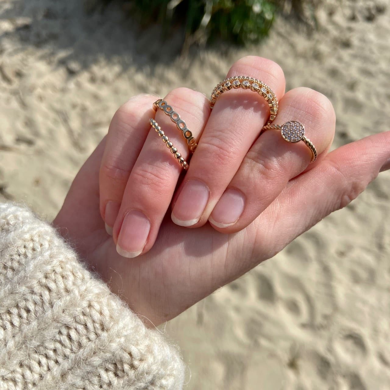 Gros plan main portant plusieurs bagues fines en plaqué or