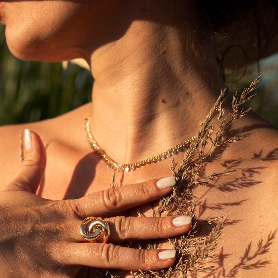 femme avec un chapeau portant des bijoux or