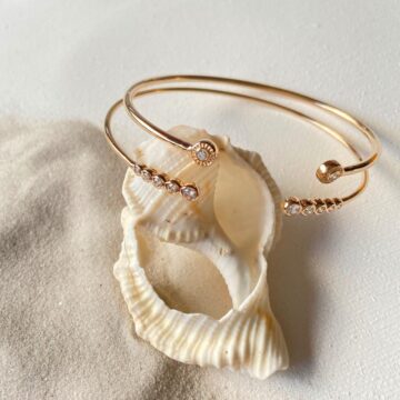 composition de deux bracelets jonc plaqué or sur un coquillage