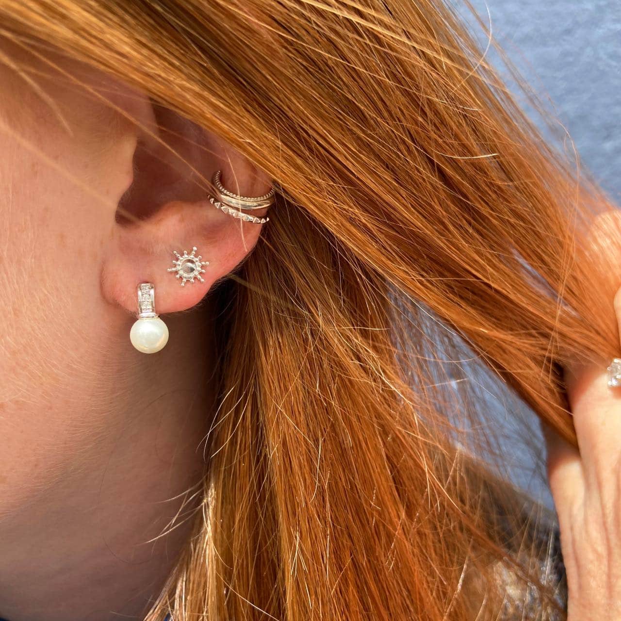Boucles d'oreilles perle et argent portées par une jeune fille aux cheveux roux