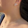 Boucles d'oreilles en argent et zirconium portées par une jeune femme brune