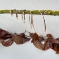 créoles fines en plaqué or de 16 à 60 mm présentées sur une tige d'arbuste