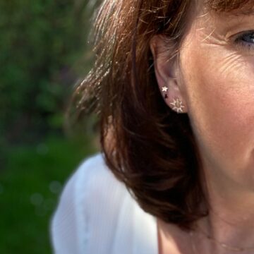 femme portant des boucles d'oreilles plaqué or étoile