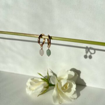 gros plan sur des petites créoles plaqué or agrémentées de perles rose et verte