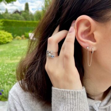jeune fille brune portant une bague en argent avec pierre de nacre et oxydes bleu et arnget