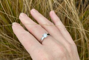 gros plan main portant une bague en argent solitaire